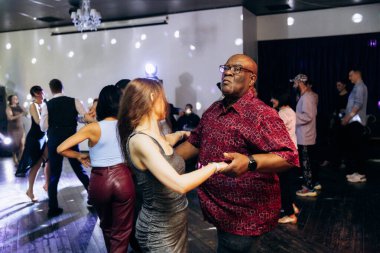 Kharkiv, Ukrayna 15.05.24 kişi bir kulüpte salsa dansı yapıyor. Parlak ışıkları olan bir gece kulübünde sosyal dans.