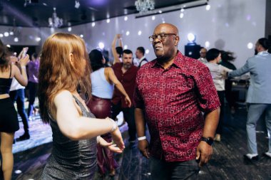 Kharkiv, Ukrayna 15.05.24 kişi bir kulüpte salsa dansı yapıyor. Parlak ışıkları olan bir gece kulübünde sosyal dans.