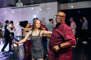 Kharkiv, Ukrayna 15.05.24 kişi bir kulüpte salsa dansı yapıyor. Parlak ışıkları olan bir gece kulübünde sosyal dans.