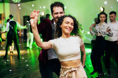 Kharkiv, Ukrayna 15.05.24 kişi bir kulüpte salsa dansı yapıyor. Parlak ışıkları olan bir gece kulübünde sosyal dans.