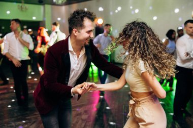 Kharkiv, Ukrayna 15.05.24 kişi bir kulüpte salsa dansı yapıyor. Parlak ışıkları olan bir gece kulübünde sosyal dans.