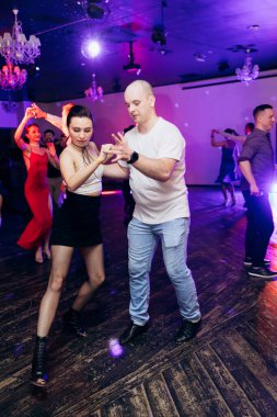 Kharkiv, Ukrayna 15.05.24 kişi bir kulüpte salsa dansı yapıyor. Parlak ışıkları olan bir gece kulübünde sosyal dans.