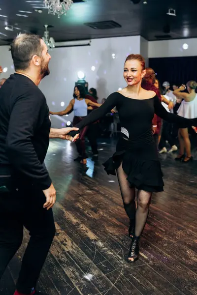 Kharkiv, Ukrayna 15.05.24 kişi bir kulüpte salsa dansı yapıyor. Parlak ışıkları olan bir gece kulübünde sosyal dans.