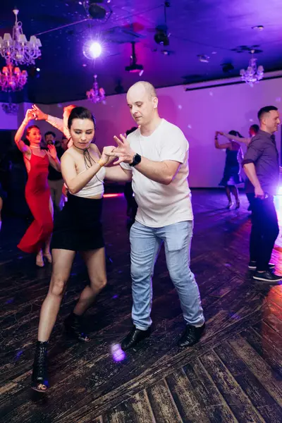 Kharkiv, Ukrayna 15.05.24 kişi bir kulüpte salsa dansı yapıyor. Parlak ışıkları olan bir gece kulübünde sosyal dans.