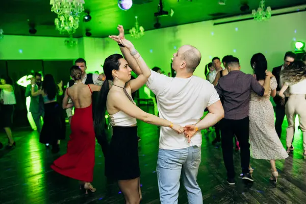 Kharkiv, Ukrayna 15.05.24 kişi bir kulüpte salsa dansı yapıyor. Parlak ışıkları olan bir gece kulübünde sosyal dans.