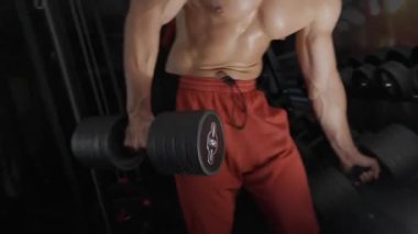 Pompalı adam spor salonunda antrenman yapıyor. Vücut geliştirici dambıl, egzersiz makinesi, halter pompalıyor.