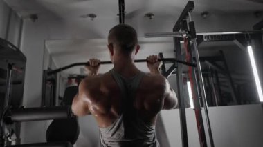Pompalı adam spor salonunda antrenman yapıyor. Vücut geliştirici dambıl, egzersiz makinesi, halter pompalıyor.