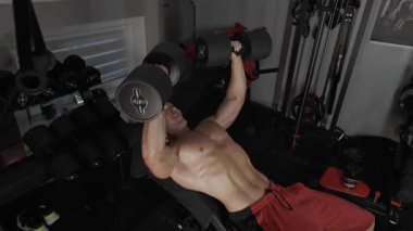 Pompalı adam spor salonunda antrenman yapıyor. Vücut geliştirici dambıl, egzersiz makinesi, halter pompalıyor.