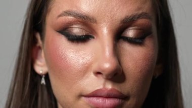 Makyajlı kız takma kirpiklerini çıkarıyor..
