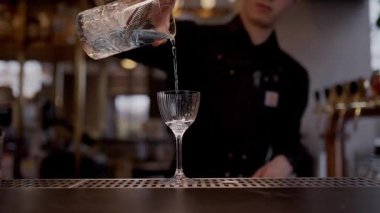 Barmen restoranda bardağa su doldurur.