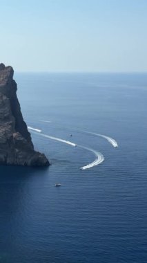 Yatlar yazın mavi denizde yelken açar.