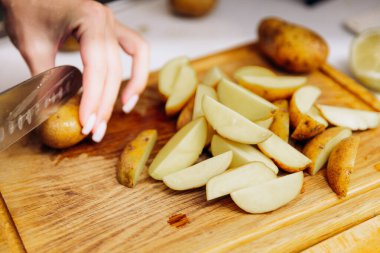 Çiğ patatesler fırında pişirmek için dilimlenir.