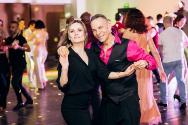 Kharkiv, Ukrayna 15.05.24 kişi bir kulüpte salsa dansı yapıyor. Parlak ışıkları olan bir gece kulübünde sosyal dans.
