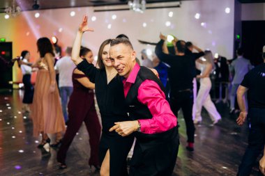 Kharkiv, Ukrayna 15.05.24 kişi bir kulüpte salsa dansı yapıyor. Parlak ışıkları olan bir gece kulübünde sosyal dans.