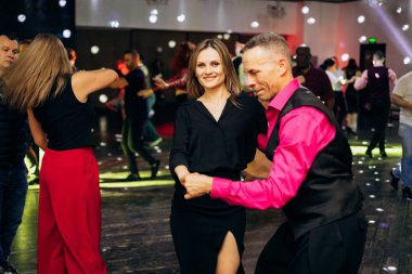 Kharkiv, Ukrayna 15.05.24 kişi bir kulüpte salsa dansı yapıyor. Parlak ışıkları olan bir gece kulübünde sosyal dans.