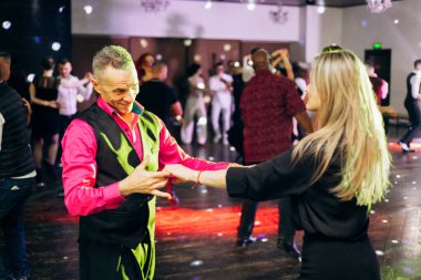 Kharkiv, Ukrayna 15.05.24 kişi bir kulüpte salsa dansı yapıyor. Parlak ışıkları olan bir gece kulübünde sosyal dans.