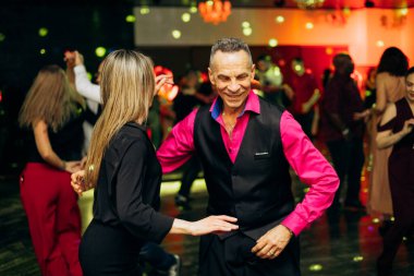 Kharkiv, Ukrayna 15.05.24 kişi bir kulüpte salsa dansı yapıyor. Parlak ışıkları olan bir gece kulübünde sosyal dans.