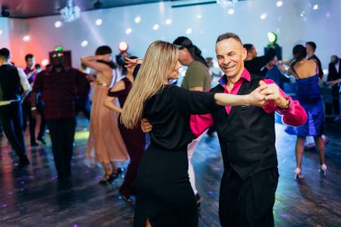 Kharkiv, Ukrayna 15.05.24 kişi bir kulüpte salsa dansı yapıyor. Parlak ışıkları olan bir gece kulübünde sosyal dans.