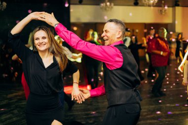 Kharkiv, Ukrayna 15.05.24 kişi bir kulüpte salsa dansı yapıyor. Parlak ışıkları olan bir gece kulübünde sosyal dans.