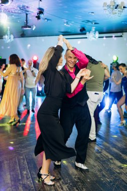 Kharkiv, Ukrayna 15.05.24 kişi bir kulüpte salsa dansı yapıyor. Parlak ışıkları olan bir gece kulübünde sosyal dans.