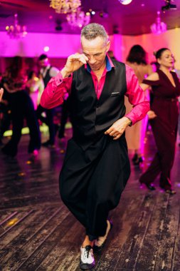 Kharkiv, Ukrayna 15.05.24 kişi bir kulüpte salsa dansı yapıyor. Parlak ışıkları olan bir gece kulübünde sosyal dans.