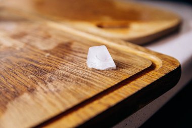 Tahta kokteyl tahtasının üzerinde bir buz parçası var.