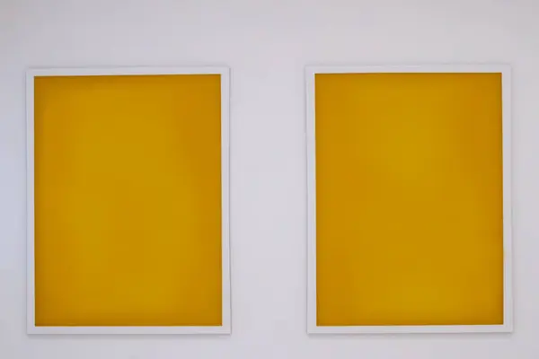 stock image Two minimalist yellow art prints framed on a white wall.