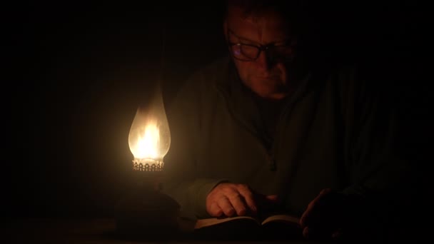 Man Reads Book Light Kerosene Lamp Night Time Close — Vídeos de Stock