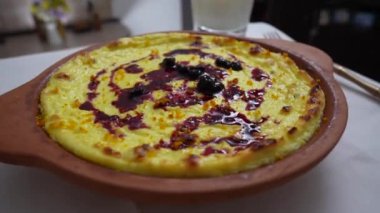 Kuru üzümlü ve irmikli süzme peynir güveci. Fırında pişmiş peynirli güveç ile seramik kase, yakın çekim. Kahvaltı için sağlıklı süt ürünleri.