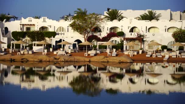 Edificios Tumbonas Sombrillas Reflejan Tranquilo Agua Mar Playa Ciudad Turística — Vídeo de stock