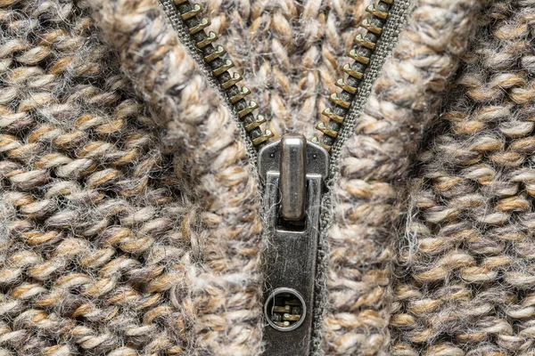 Zipper on a knitted sweater. Warm accessories, clothing, fashion concept. Close up. Fashionable jacket with zipper fastening for cold season, macro