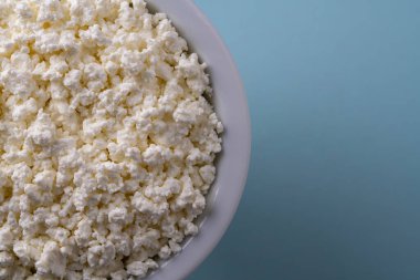 Mavi arkaplanda beyaz süzme peynir, üst görünüm, kapat, metin için boşluk kopyala