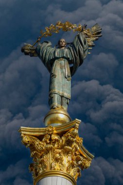 Bağımsızlık anıtı ve kalın siyah duman Ukrayna ve Rusya arasındaki savaş sırasında gökyüzünü kaplıyor. Bu bir melek heykeli, bakır ve altından yapılmış, uzun sütunun üzerinde duruyor, Kyiv, Ukrayna