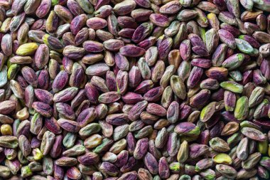 Fıstıklı çekirdekleri kabuksuz istifleyin. Kapatın. Kabuksuz şam fıstığı, üst manzara. Bütün çekirdekler