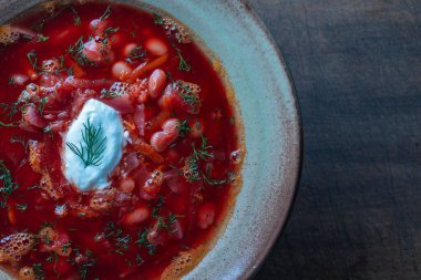 Ahşap bir zeminde seramik tabakta Ukrayna ulusal çanak kırmızı borsch 'u. Pancar çorbası Ukrayna 'da ulusal bir yemektir, üst görünüm, metin için kopyalama alanı
