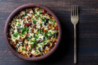 Haşlanmış patates, havuç, soğan, domates, kuru erik ve peynir ahşap arka planda bir kil kasede, yakın plan, üst manzara