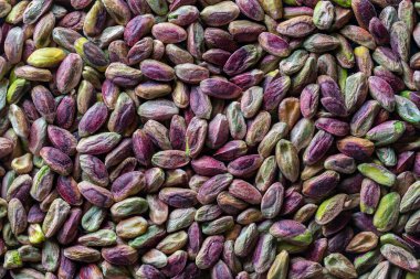 Fıstıklı çekirdekleri kabuksuz istifleyin. Kapatın. Kabuksuz şam fıstığı, üst manzara. Bütün çekirdekler