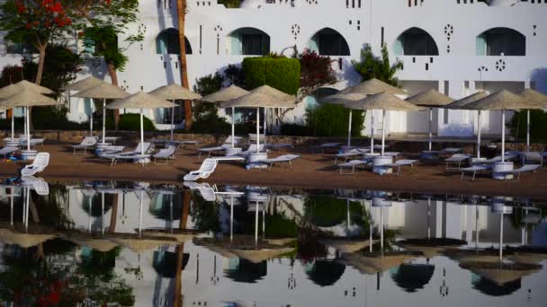 Edificios Tumbonas Sombrillas Reflejan Tranquilo Agua Mar Playa Ciudad Turística — Vídeos de Stock
