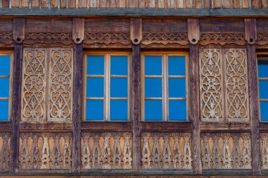 Batı Ukrayna 'daki Karpat köyünde, dağlardan yapılmış ahşap kirişlerden yapılmış ahşap bir evin ön cephesindeki pencereler...