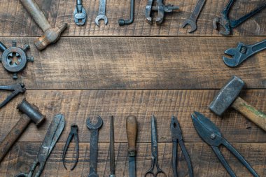 Vintage tools displayed on a background of wooden board, close up, top view, copy space. Dirty set old working tools