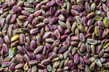 Fıstıklı çekirdekleri kabuksuz istifleyin. Kapatın. Kabuksuz şam fıstığı, üst manzara. Bütün çekirdekler