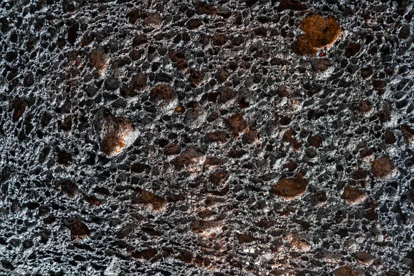Black burnt toast bread slice texture, close up. Pattern of burnt black bread, abstract background, macro. Top view