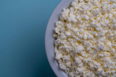 Mavi arkaplanda beyaz süzme peynir, üst görünüm, kapat, metin için boşluk kopyala