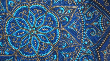 Decorative ceramic plate with blue and golden colors, painted plates, close up, rotates, handmade. Decorative porcelain plate painted with acrylic paints, handwork
