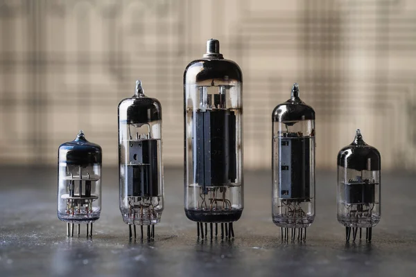 Old diode lamps of different sizes on a table, close up. Several different vacuum tubes for old radio and TV