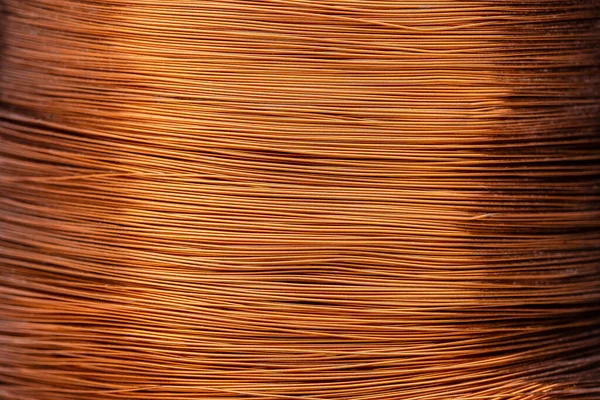 Metal texture of a coil of copper wire, close-up. Coil of thin copper wire on the background