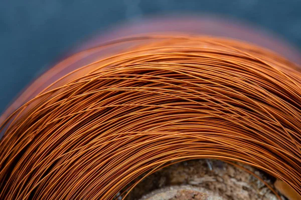 Metal texture of a coil of copper wire, close-up. Coil of thin copper wire on the background