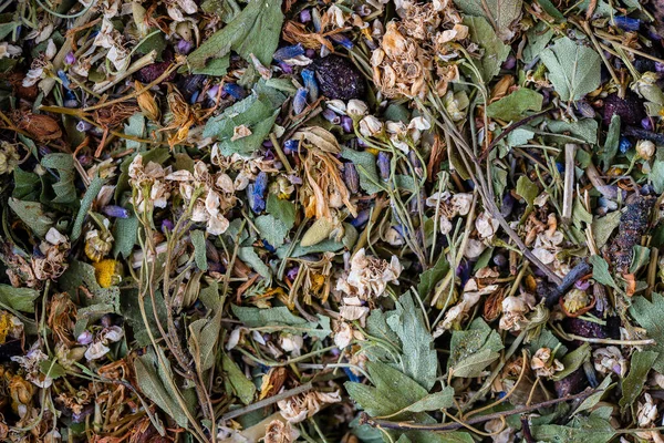 Dry flower and herbal tea leaves on background. Herbal collection of chamomile, cornflower, mint, lemongrass, wild rose and linden, top view, close up