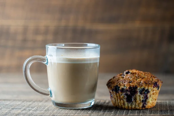Delicioso Muffin Com Mirtilos Copo Vidro Cappuccino Uma Mesa Madeira — Fotografia de Stock