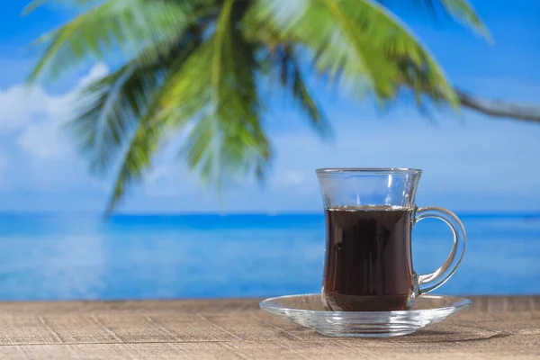 Kubek Gorącej Czarnej Herbaty Drewnianym Stole Wodą Morską Palmą Kokosową — Zdjęcie stockowe